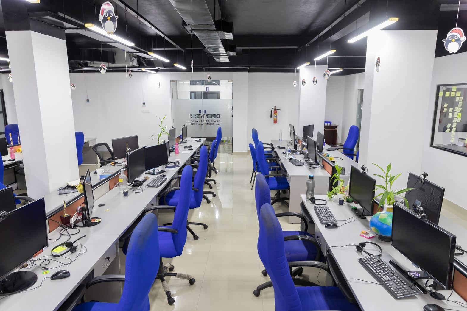 Open-plan software team workspace with monitors along a bay of desks
